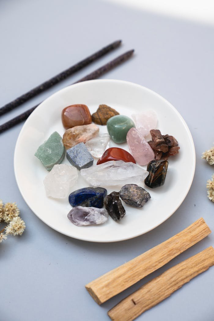 services-03 A collection of colorful healing crystals displayed on a white ceramic plate for spiritual therapy.